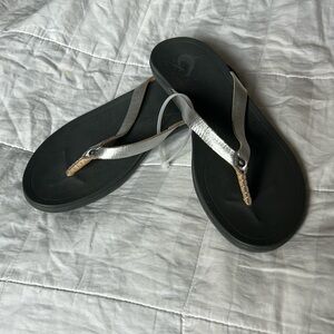 Olukai silver/tan flip flop.